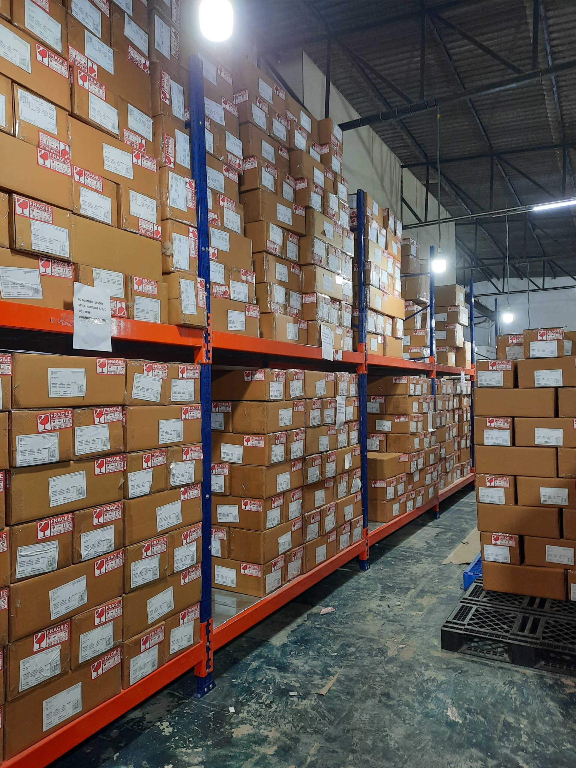 Metal steel racks, Pallet Racks in blue and orange color with boxes kept all over it having only 2 levels and some boxes are kept on pallets on the floor