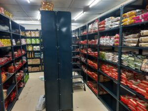 Slotted angle racks for shop in dark grey color used in a supermarket with daily house hold items kept in the slotted angle racks