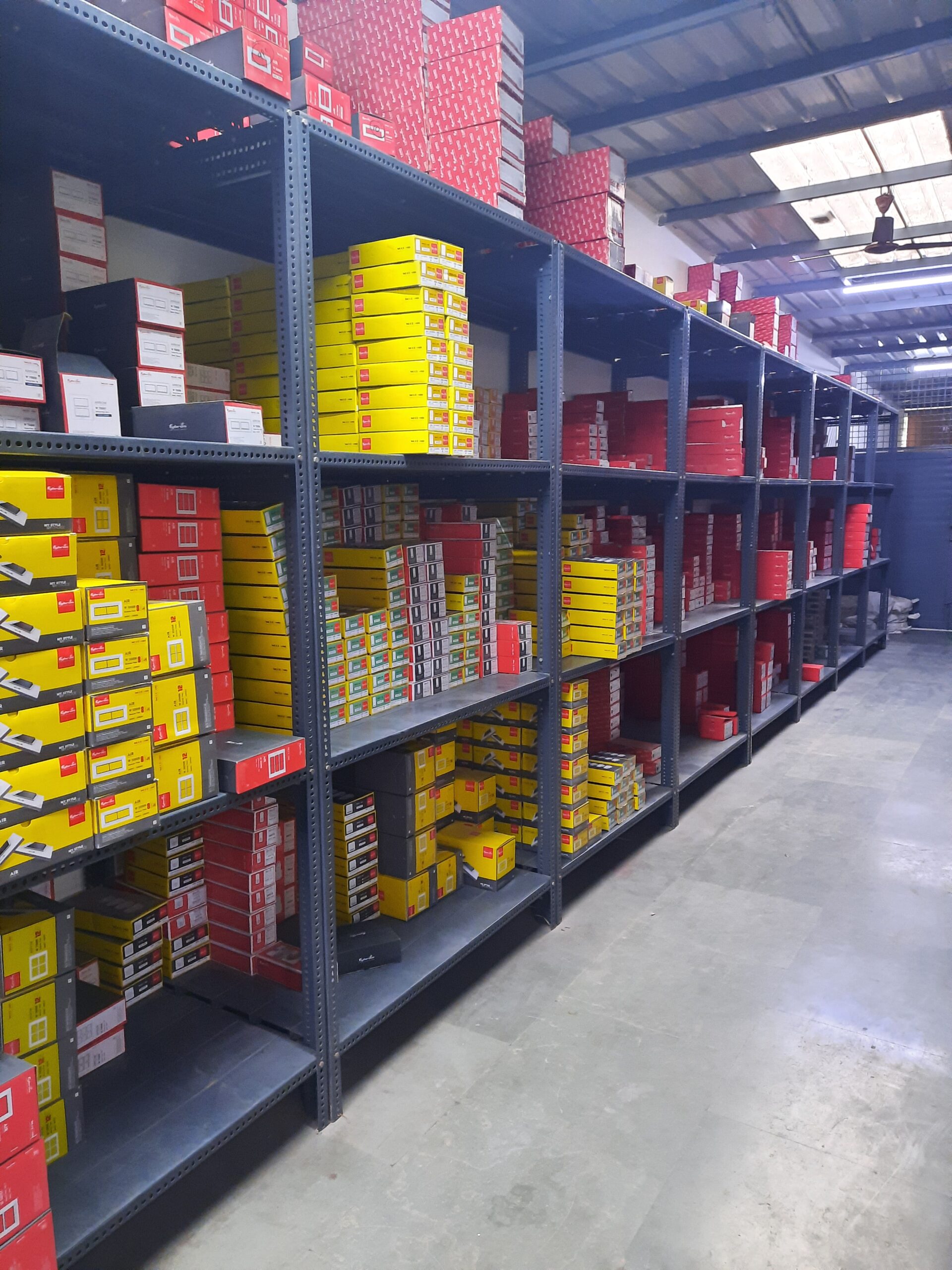 "GKSP Racking", Slotted angle rack Manufacturer in Bahadurgarh- Manufacturing slotted angle racks with GI panels from a decade. This rack has 7 feet height and is in dark grey color and have stored many types of boxes with electrical items/materials inside.